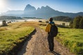 Man hiker on the road admire sunrise at Alpe di Siusi, Dolomites mountains, Italy Royalty Free Stock Photo