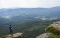 Man hiker stands over a cliff and enjoying a beautiful view of a green mountain valley. Carpathians, Ukraine Royalty Free Stock Photo