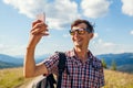 Man hiker taking selfie with smartphone in Carpathian mountains on hill peak. Traveler backpaker enjoys view Royalty Free Stock Photo