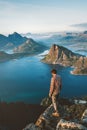 Man hiker traveling in Norway solo hiking in mountains of Lofoten islands outdoor traveler standing on cliff edge Royalty Free Stock Photo