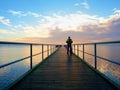 Man hiker walk on wet mole above sea to Sun. Fantastic morning Royalty Free Stock Photo