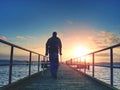 Man hiker walk on wharf mole above sea to Sun. Fantastic morning Royalty Free Stock Photo