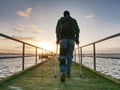 Man hiker walk on wharf mole above sea to Sun. Fantastic morning Royalty Free Stock Photo