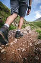 Man hiker walking on mountain rocks with sticks. Beautiful weather with Scotland nature. Detail of hiking boots on the difficult p Royalty Free Stock Photo