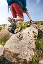 Man hiker walking on mountain rocks with sticks. Beautiful weather with Scotland nature. Detail of hiking boots on the difficult p Royalty Free Stock Photo