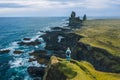 Man hiker in yellow jacket stand on the peak of the rock in outdoor park in Iceland. Londrangar Royalty Free Stock Photo