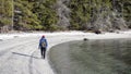 Man hikes on Galiano Island British Columbia beach near the ocean and forest with walking stick