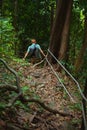 Man hikes in mountainous tropical forest holding safety ropes Royalty Free Stock Photo