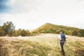 Man hiking on autumn day through beautiful nature landscape. Misty Mountain Peak. Rear View. Cloudy sky