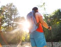 Man hiking with backpac and sticks in mountains in sunset Royalty Free Stock Photo