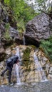 Man with hiking backpack drinking water from famous waterfall located in the Olympus mountains, where God Zeus used to bath Royalty Free Stock Photo
