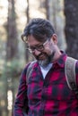 Man hiking and enjoying in a woods forest location. Side view of a man wearing a bag walking through a forest. Happy adult young Royalty Free Stock Photo