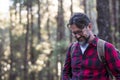 Man hiking and enjoying in a woods forest location. Side view of a man wearing a bag walking through a forest. Happy adult young Royalty Free Stock Photo