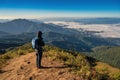 Man hiking looking at mountain range on the top of mountain in tropical forest