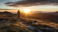 Man hiking on mountain as the sun rises with border collie dog