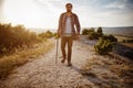 Man hiking in the mountains using pole and looking away