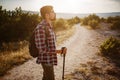 Man hiking in the mountains using pole and looking away