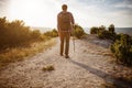 Man hiking in the mountains using pole and looking away