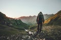Man hiking at sunset mountains with heavy backpack