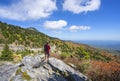 Hiker standing on cliff edge enjoying scenic fall view. Royalty Free Stock Photo