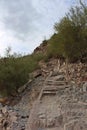 A man hiking up the rocky, uneven trail to the Summit of Mount Piestewa in Phoenix, Arizona