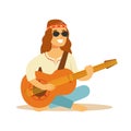 Man Hippie Dressed In Classic Woodstock Sixties Hippy Subculture Clothes Sitting Playing Guitar In Round Shades