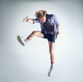 Man, hipster and fashion jump in studio dancing isolated, grey background or mockup space. Male person, glasses and