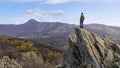 Man on his back ascended to a rocky summit and contemplating the views of the green mountain landscape. La Hiruela Madrid