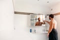 Man in his bathroom touching his smart mirror