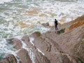 Man with his board is getting ready for surfing on the flysh cliff at La Concha Beach in San Sebastian