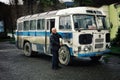 a man at his bus which is used as a camper van with his family opening the door