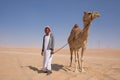 Man with his camel in a desert. Royalty Free Stock Photo