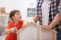 Man and his child playing builders with wooden doll house Royalty Free Stock Photo