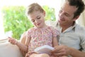 Man with his daughter playing games on a tablet Royalty Free Stock Photo