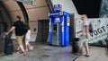 Blurred images of travelers in front of a automated bank machine in Europe