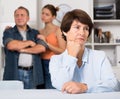 Man and his daughter are sympathying their sad mother who is sitting at the table Royalty Free Stock Photo