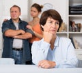 Man and his daughter are sympathying their sad mother who is sitting at the table Royalty Free Stock Photo