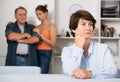 Man and his daughter are sympathying their sad mother who is sitting at the table Royalty Free Stock Photo