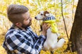 Man with his dog at autumn park. Guy playing with jack russell terrier outdoors. Pet and people concept.