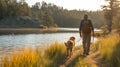 A man and his dog exploring a tranquil lakeside trail Royalty Free Stock Photo