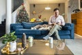 Man and his dog are sitting in the living room with Christmas decorations Royalty Free Stock Photo