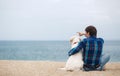 Man with his dog at the summer beach sitting back to camera Royalty Free Stock Photo