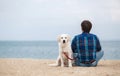 Man with his dog at the summer beach sitting back to camera Royalty Free Stock Photo