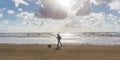 Man and his dog walking at the beach at sunset or sunrise Royalty Free Stock Photo