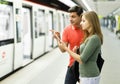 Man with his girlfriend are standing on platform and choosing route