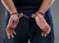 Man with his hands handcuffed in criminal concept