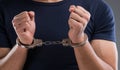 Man with his hands handcuffed in criminal concept