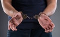 Man with his hands handcuffed in criminal concept