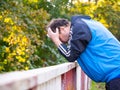 Man with his head in his hands and leaning on the railing, worried and sad Royalty Free Stock Photo