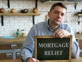 Man at his home shows Mortgage relief sign.